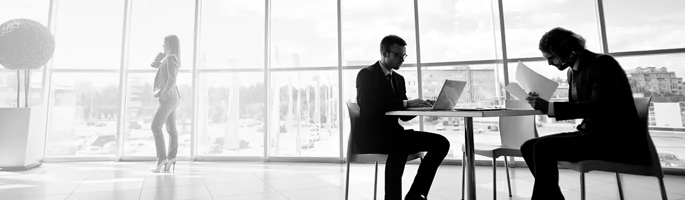 Two students using a laptop and notes to learn about business continuity management